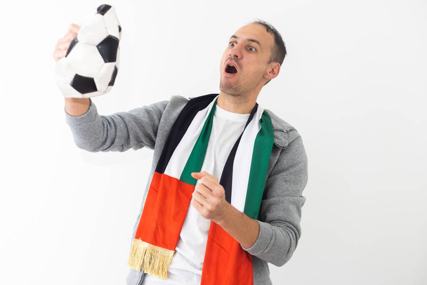 Soccer Fan. Emotional Guy Shouting Celebrating Victory Of Team Holding Ball Posing On Studio Background. High quality photo - Photo, Image