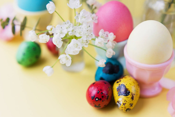 Húsvéti tojás és virágok sárga alapon. Húsvét háttér pasztell színek részletek. Tavaszi nyaralás - Fotó, kép
