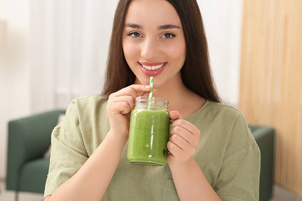 Beautiful young woman drinking delicious smoothie indoors - Photo, Image