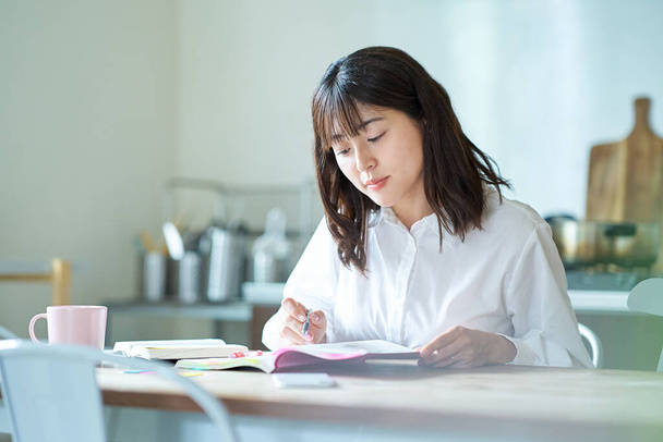Взрослая женщина учится с текстом на дому - Фото, изображение
