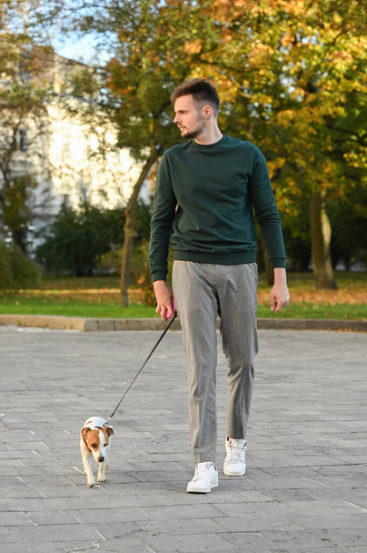 Man with adorable Jack Russell Terrier on city street. Dog walking - Photo, image