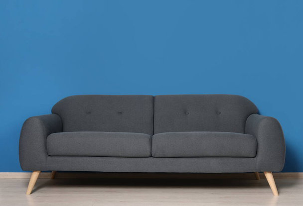 Stylish grey sofa near blue wall in room. Interior design - Φωτογραφία, εικόνα