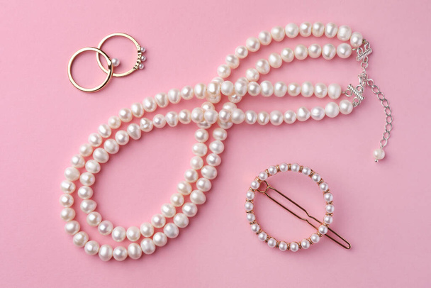 Elegant pearl jewelry on pink background, flat lay - Foto, Bild