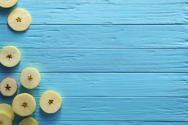 Food photography. Slices of apple on light blue wooden table, flat lay with space for text - Фото, зображення