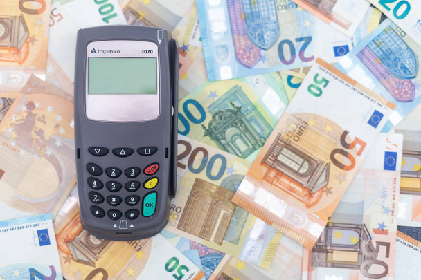 Terminal de pagos Pos y billetes en euros de diferentes denominaciones en segundo plano - Foto, Imagen