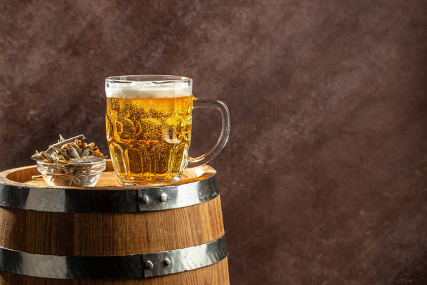 Ποτήρι μπύρας και σνακ σε ξύλινη κάννη. banner, μενού, μέρος συνταγών για κείμενο. - Φωτογραφία, εικόνα