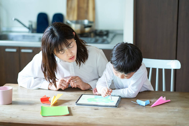madre e hijo jugando con una tableta PC en la habitación - Foto, Imagen