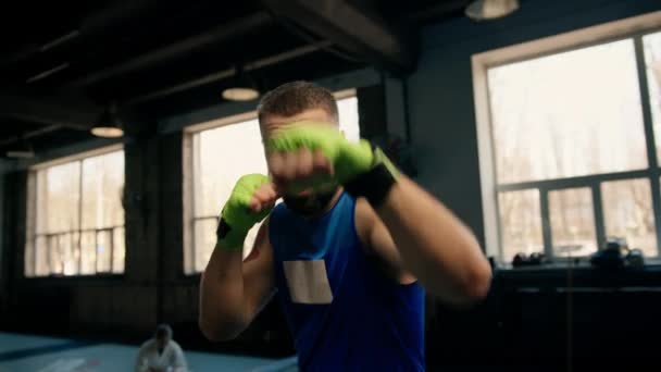 Zbliżenie portret boksera z elastycznymi bandażami na rękach walczącego z cieniem - Materiał filmowy, wideo