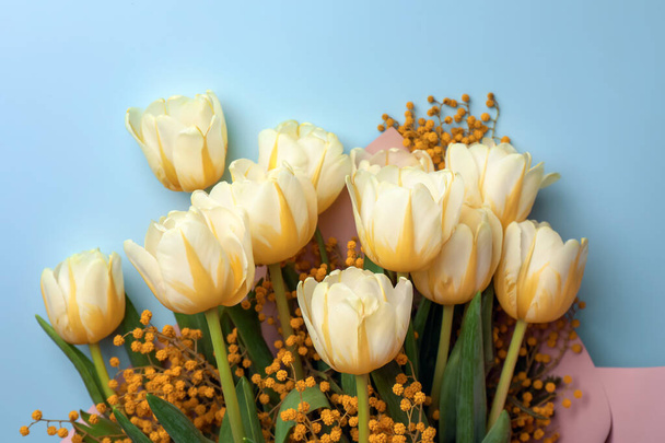 Bouquet with beautiful tulips and mimosa flowers on light grey background, top view - Valokuva, kuva