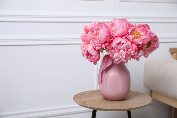 Beautiful bouquet of pink peonies in vase on wooden table indoors. Space for text - Fotoğraf, Görsel