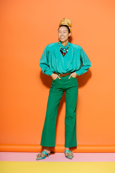 Full length of cheerful african american model in summer outfit posing on colorful background  - 写真・画像