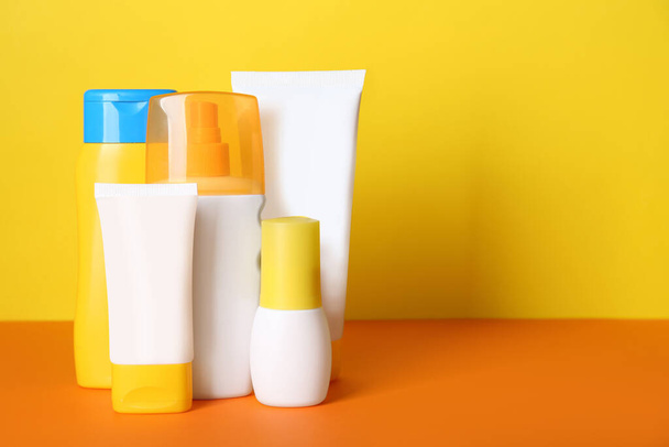 Different suntan products on color background. Space for text - Fotoğraf, Görsel