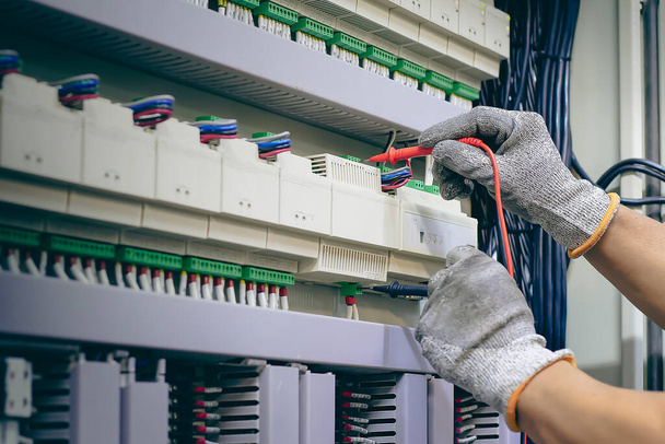 Ingénieur électricien contrôle fonctionnement de l'armoire de commande électrique, concept de maintenance - Photo, image