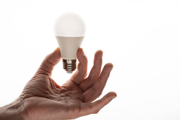 The man holds a light bulb in his hand. Light - Foto, imagen