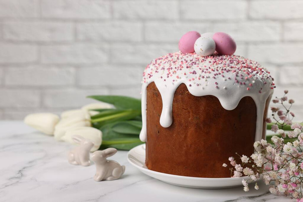 Tasty Easter cake with decorative sugar eggs and flowers on white marble table. Space for text - Foto, Imagem