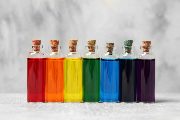 Glass bottles with different food coloring on white table - Photo, Image