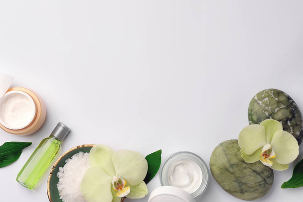 Flat lay composition with different spa products and beautiful flowers on white table. Space for text - Fotografie, Obrázek