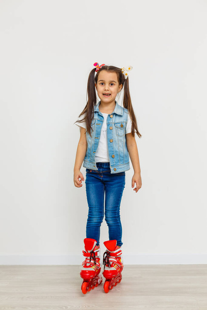 Cute girl on roller skates against white background - Foto, Imagen