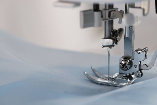 Sewing machine with light blue fabric, closeup. Space for text - Foto, Bild