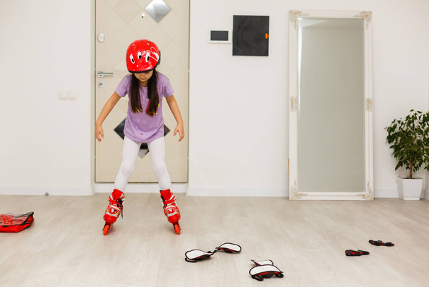 Cute little girl with roller skates in living room - Photo, Image