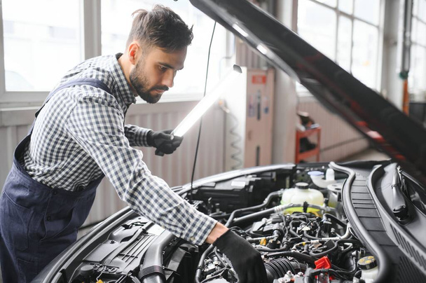 Handsome Car Mechanic is Posing in a Car Service - Photo, image