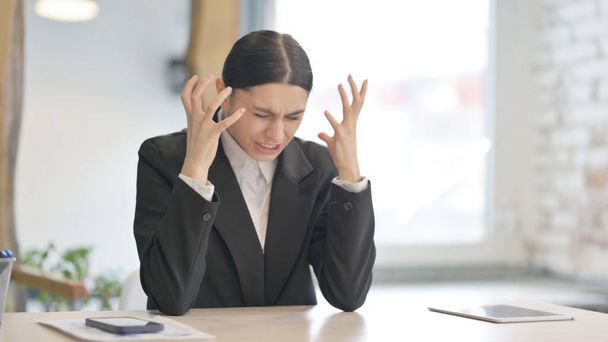 Joven empresaria enojada en frustración sentada en el trabajo - Foto, imagen