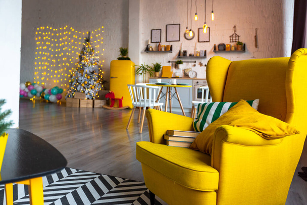 Trendikäs muoti ylellinen sisustus skandinaaviseen tyyliin yksiö kirkkaan keltainen huonekalut ja koristeltu uusi vuosi valot. - Valokuva, kuva