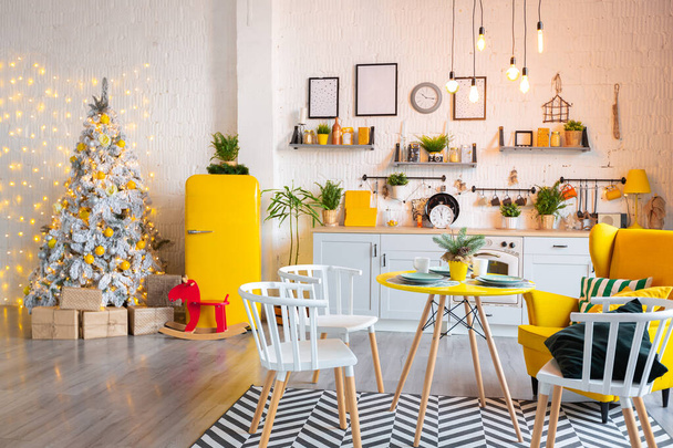 Moda moda design de interiores de luxo em estilo escandinavo de apartamento estúdio com mobiliário amarelo brilhante e decorado com luzes do ano novo. - Foto, Imagem