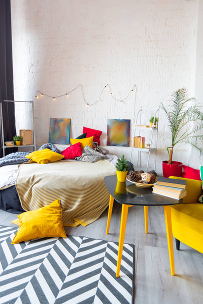 Trendy fashion luxury interior design in Scandinavian style of studio apartment with bright yellow furniture and decorated with new year lights. - Φωτογραφία, εικόνα