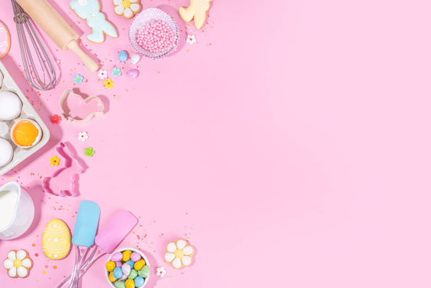 Cute pink sweet baking flat lay for Easter holiday. Cooking background with baking ingredients, rolling pin, whisk for whipping, cookie and cutters, sugar sprinkling, flour, top view copy space  - Zdjęcie, obraz