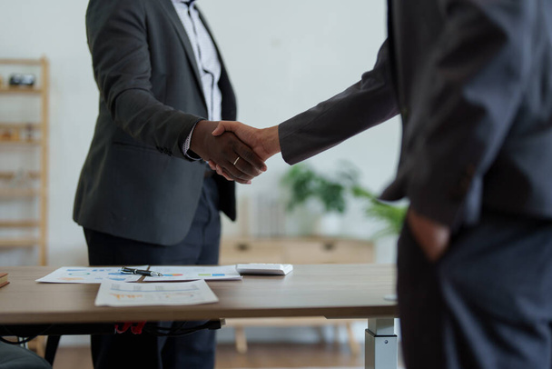 african american and asian people hand shaking successful corporate partnership deal welcoming opportunity in office agreement professional greeting meeting colleagues partners. - Foto, imagen