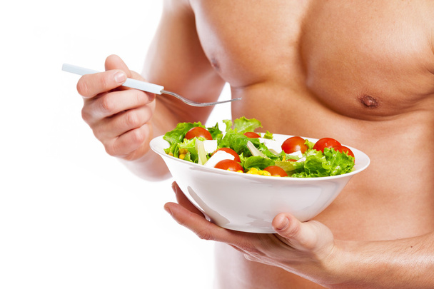 Fit man holding a bowl of  salad - Photo, image
