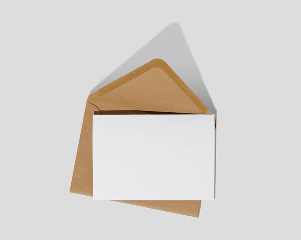 Λευκή λευκή κάρτα με καφέ φάκελο από Κραφτ σε λευκό φόντο πρότυπο mockup - Φωτογραφία, εικόνα