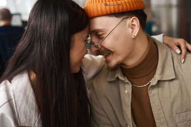 Asian female giving hug to smiling happy young Caucasian male in eyeglasses - Photo, image