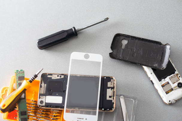 Techniker repariert Innenseite des Mobiltelefons durch Lötkolben. das Konzept von Daten, Hardware, Technologie - Foto, Bild
