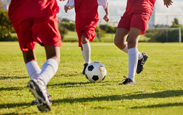Kids team, soccer or legs with soccer ball in workout, fitness game or exercise on nature park grass, high school stadium or field. Football or sports training with energy in health or girls wellness. - Foto, afbeelding