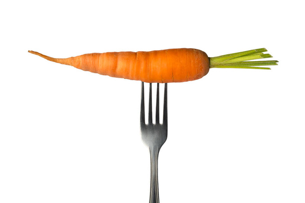 carrot on a folk, a root vegetable isolated on white background, healthy eating concept, closeup - Photo, Image