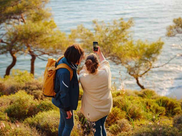 výlet do Turecka, dvě ženy si užívají západ slunce a dělat selfie nad městem Fethiye. Jednota, duševní zdraví, ekologické cestování. Turistika v horách, cestování, dobré chvíle, digitální detox - Fotografie, Obrázek