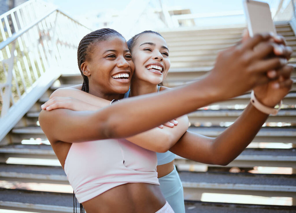 Exercise, friends and selfie on a phone with happy, relax women bonding and laughing during a workout in a city. social media, content creator and girls posing for online livestream on blog after run. - Photo, Image