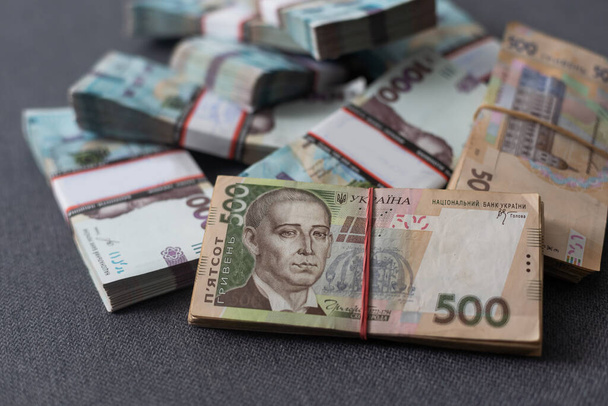 пачки украинских денег, пачки гривен, 200,500,1000 денежная концепция. Куча банкнот. Вид сбоку. - Фото, изображение