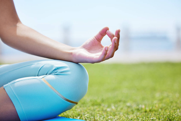 Kobieca medytacja jogi, zen i mudra ręce w lotosu stanowią do ćwiczeń natury, treningu i spokoju trawy na świeżym powietrzu. Spokojna energia, zdrowie i skupienie osoby w treningu lotosu do myślenia, wellness i zrelaksowany. - Zdjęcie, obraz