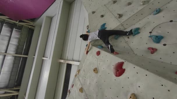  Little girl bouldering at the gym. Kids extreme sport. Low angle view. Vertical video - Footage, Video