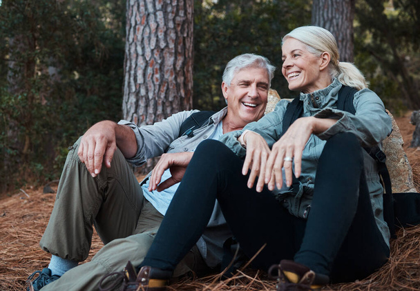 Nature, smile and hiking, old couple on floor in forest in South Africa on retirement holiday adventure. Travel, senior man and woman relax together on outdoor walk with love, happiness and health - Photo, Image