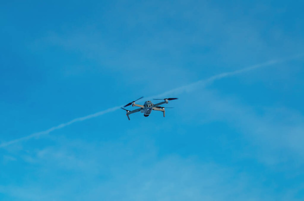 Drone quadcopter against blue sky. Air shooting, aerial reconnaissance - Fotoğraf, Görsel