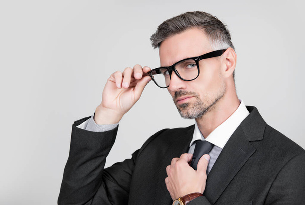 mature entrepreneur in businesslike suit and glasses on grey background. copy space. - Zdjęcie, obraz