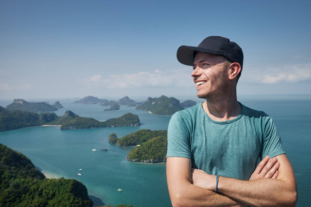 Portrait of laughing man on hill against group of tropical islands in sea, Thailan - Foto, afbeelding