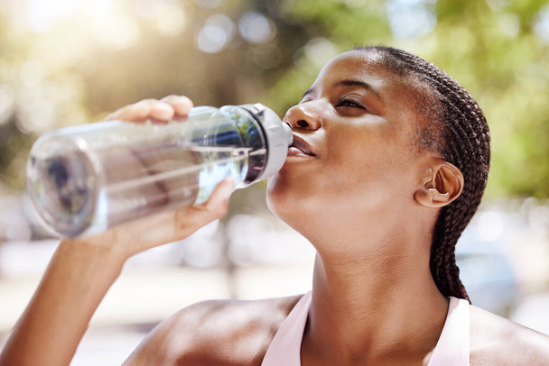 Woman, exercise and drink water outdoor, while running or training in the summer. Lady, workout and bottle for hydration in the sun, runner in park with bottle for health, wellness and beauty. - Fotografie, Obrázek