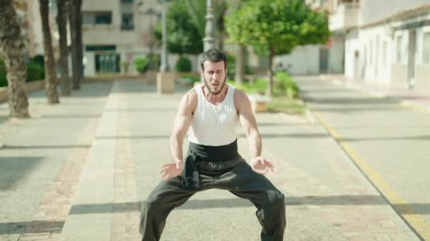 Genç İspanyol adam parkta karate dövüşçüsü eğitimi alıyor. - Video, Çekim