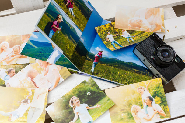 printed photos of family summer vacation lying on desk - Foto, afbeelding