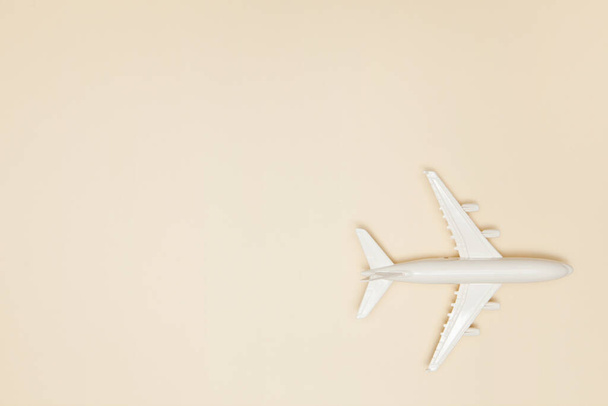 Airplane model. White plane on light brown background. Travel vacation concept. Summer background. Flat lay, top view, copy space. - Photo, image